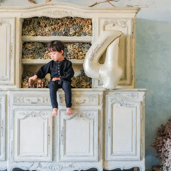 お洒落着を着用した赤ちゃんのバースデーの記念写真