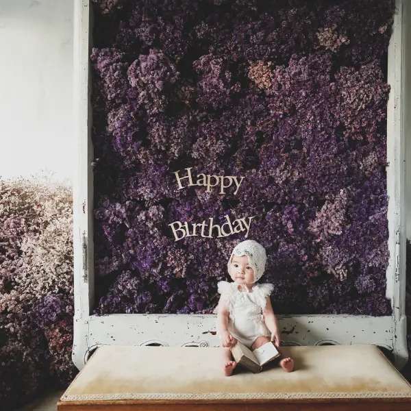 子供用の洋服を着用したベビー・ハーフバースデーの記念写真