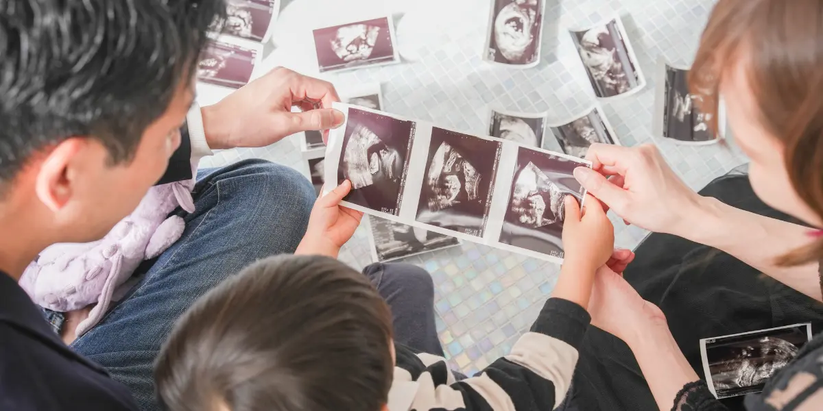 男性と子供とドレスを着用した女性のマタニティ記念写真